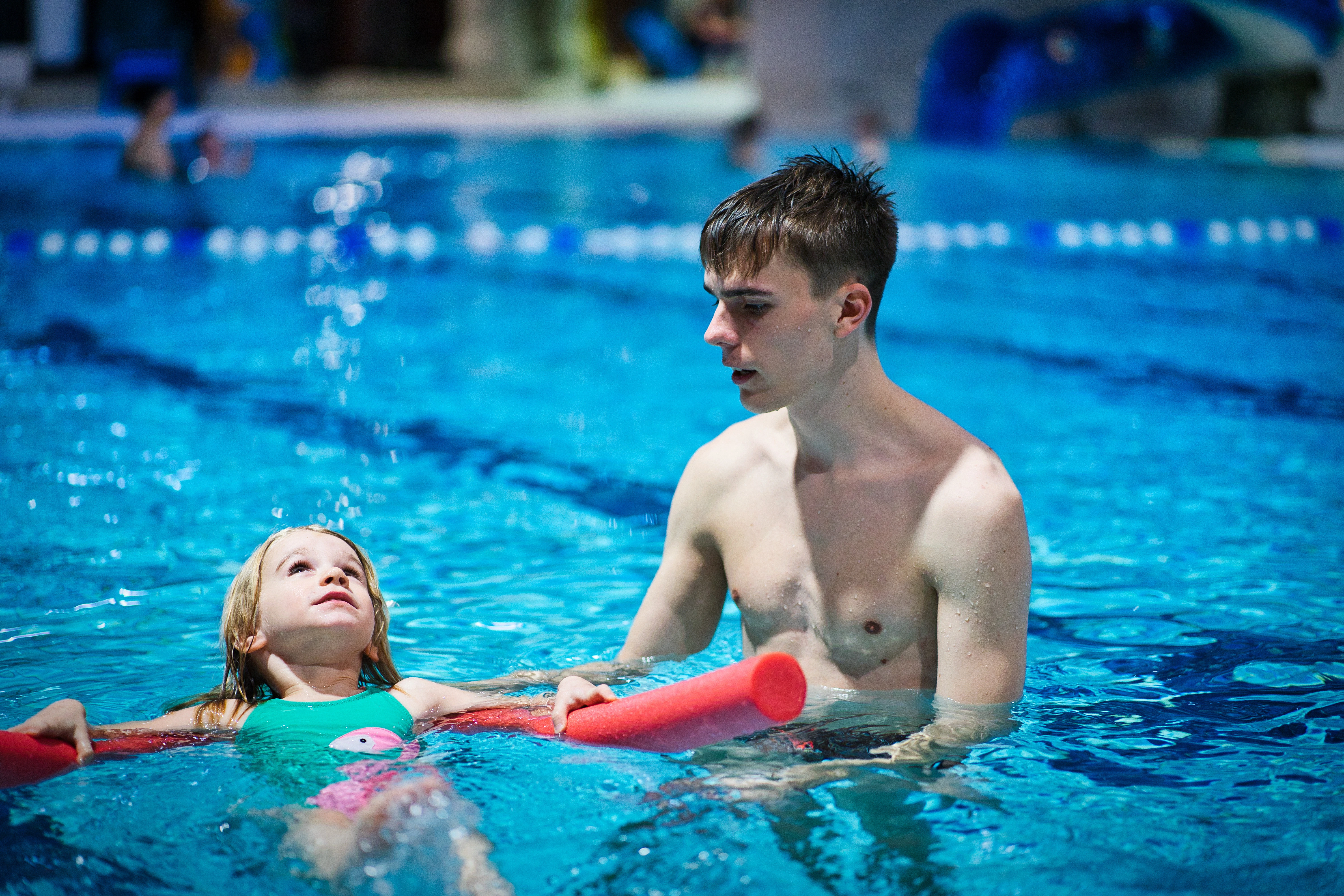 Kinder beim spielerischen Schwimmenlernen
